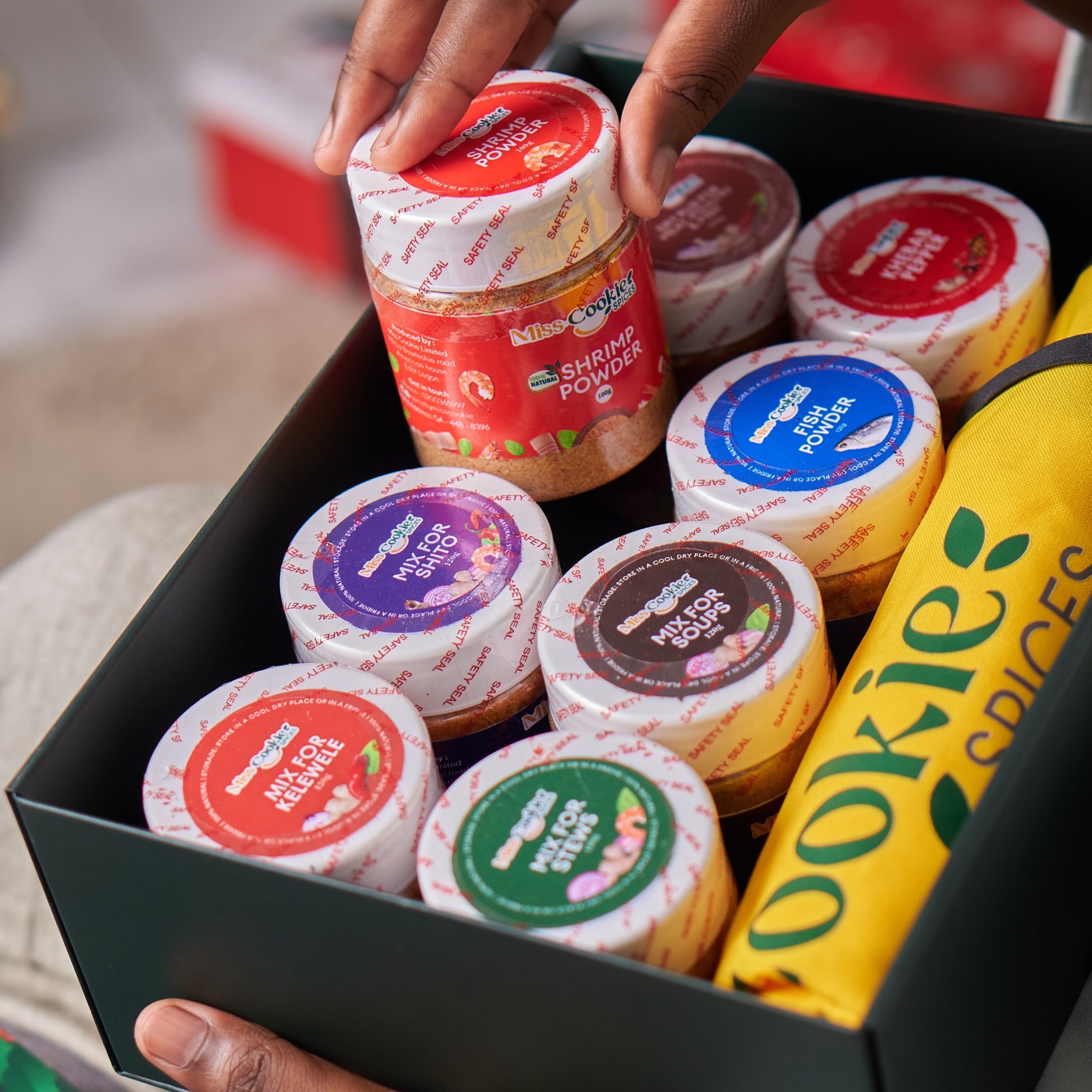 A Miss Cookie Spices gift box being packed with jars of spice blends