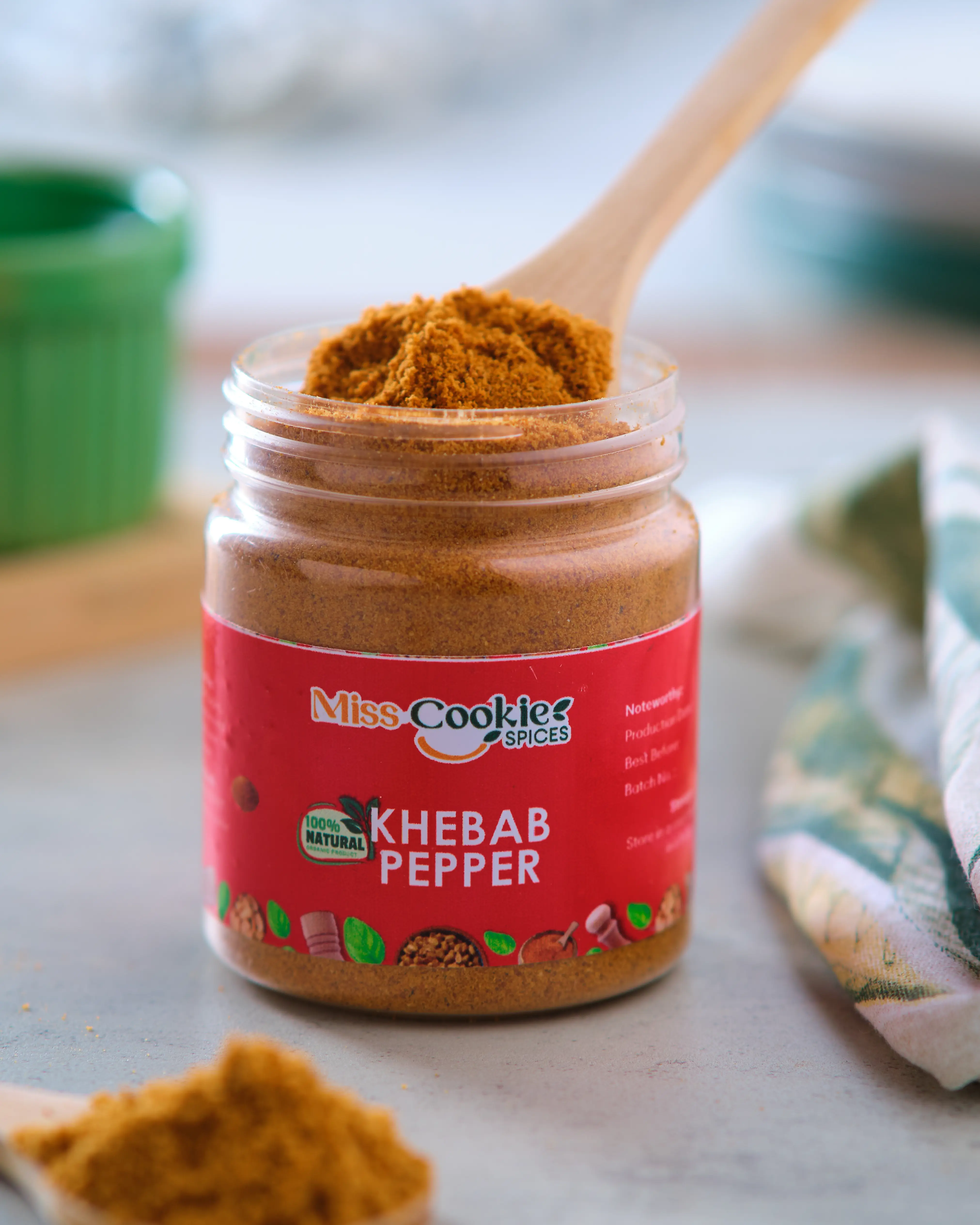 Open jar of Miss Cookie Khebab Pepper with a wooden spoon of spice on top